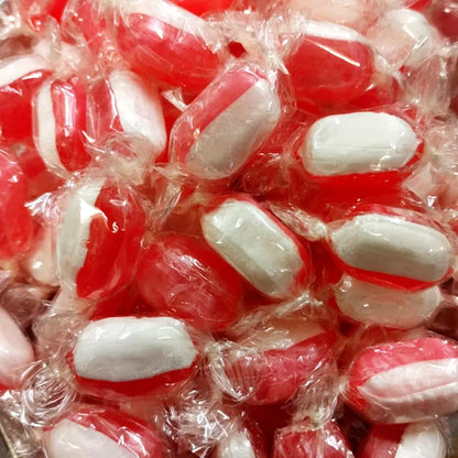 Strawberry and cream sweets with a soft, pastel pink and white swirl, shaped like small, rounded candies, arranged on a white background